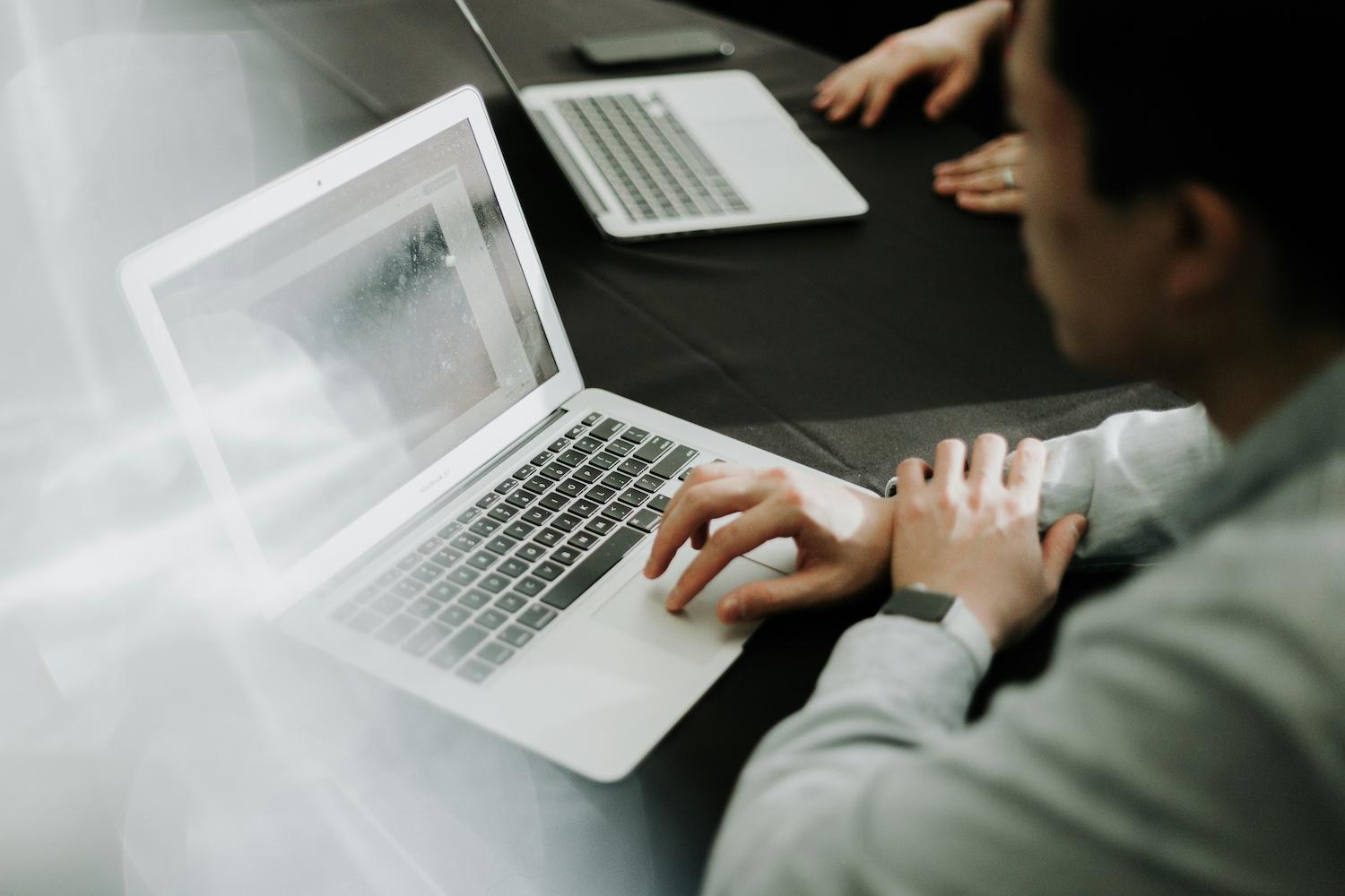 A person typing on a laptop. 