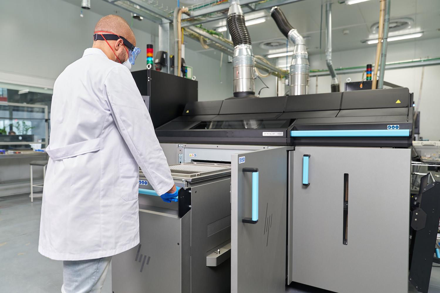 HP Metal Jet S100 Operator 3D printing metal parts in a lab
