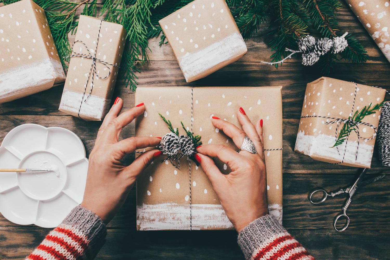 Hands Wrapping Holiday Gifts - Sustainable Holiday Gift Guide