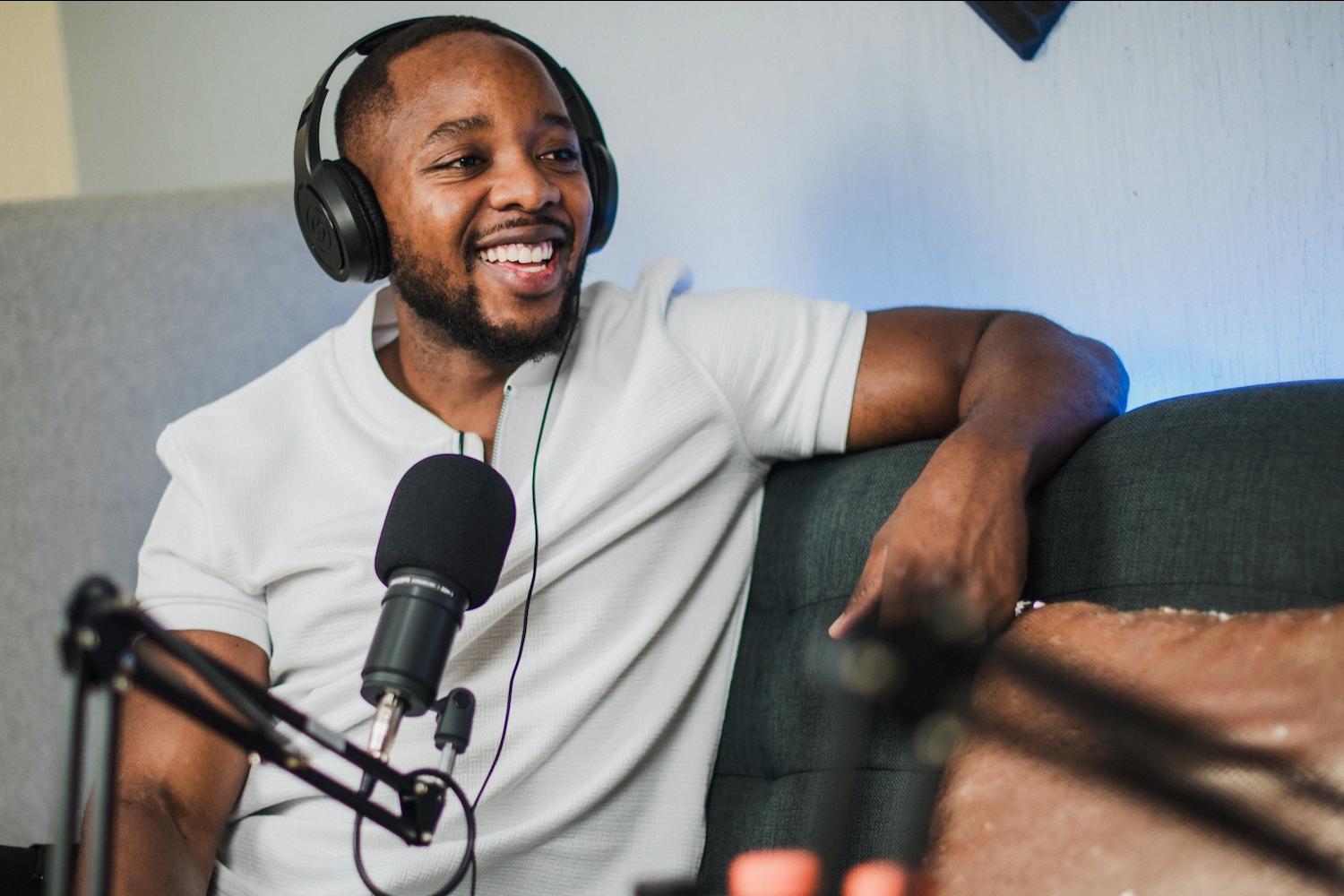 A man with headphones on speaks into a microphone. 