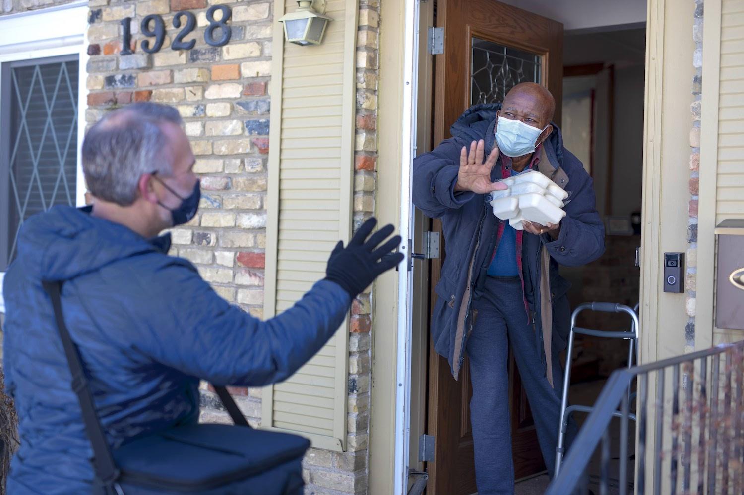 Meals on Wheels volunteer delivers food to a senior at his home 