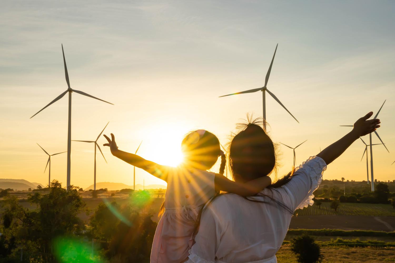 Mother and Daughter looking at wind farm - the journey to climate-positive