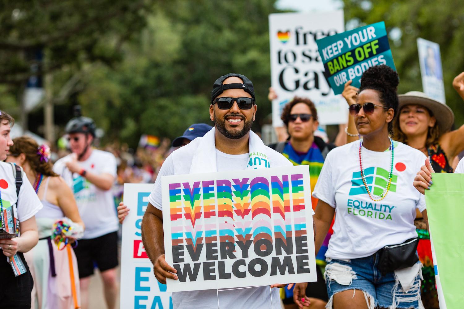 People smile and march carrying signs at a Pride Parade in St Petersburg Florida - LGBTQ+ rights