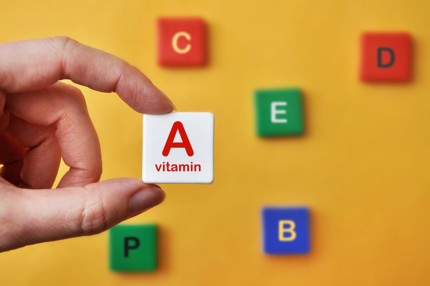 person holding letter tile that says vitamin A