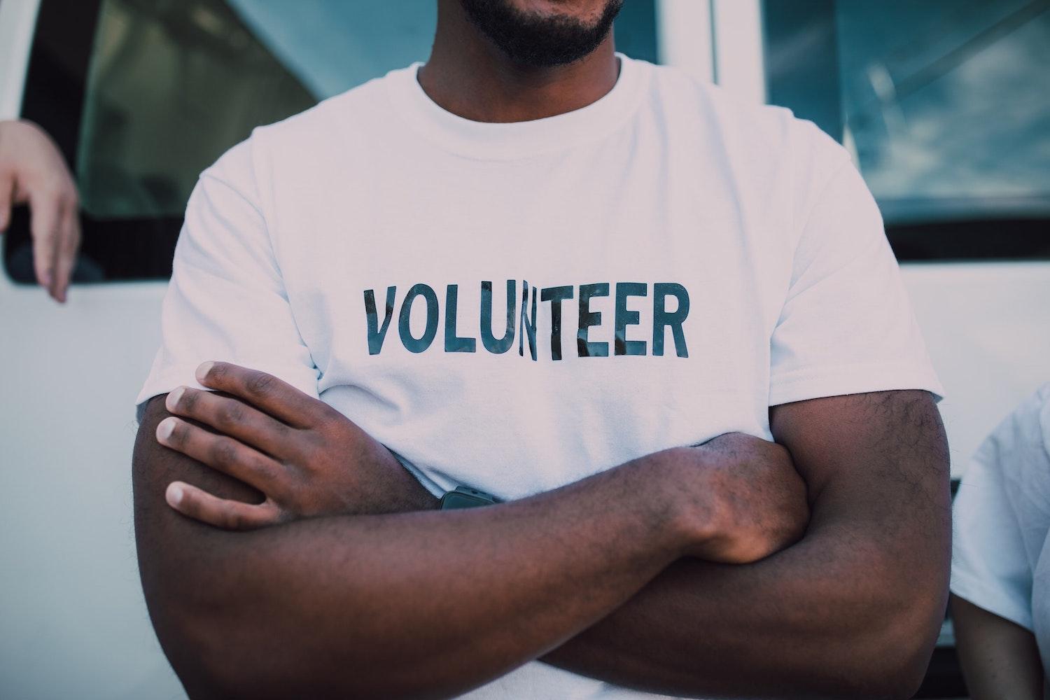 black man wearing volunteer shirt - nonprofits led by people of color
