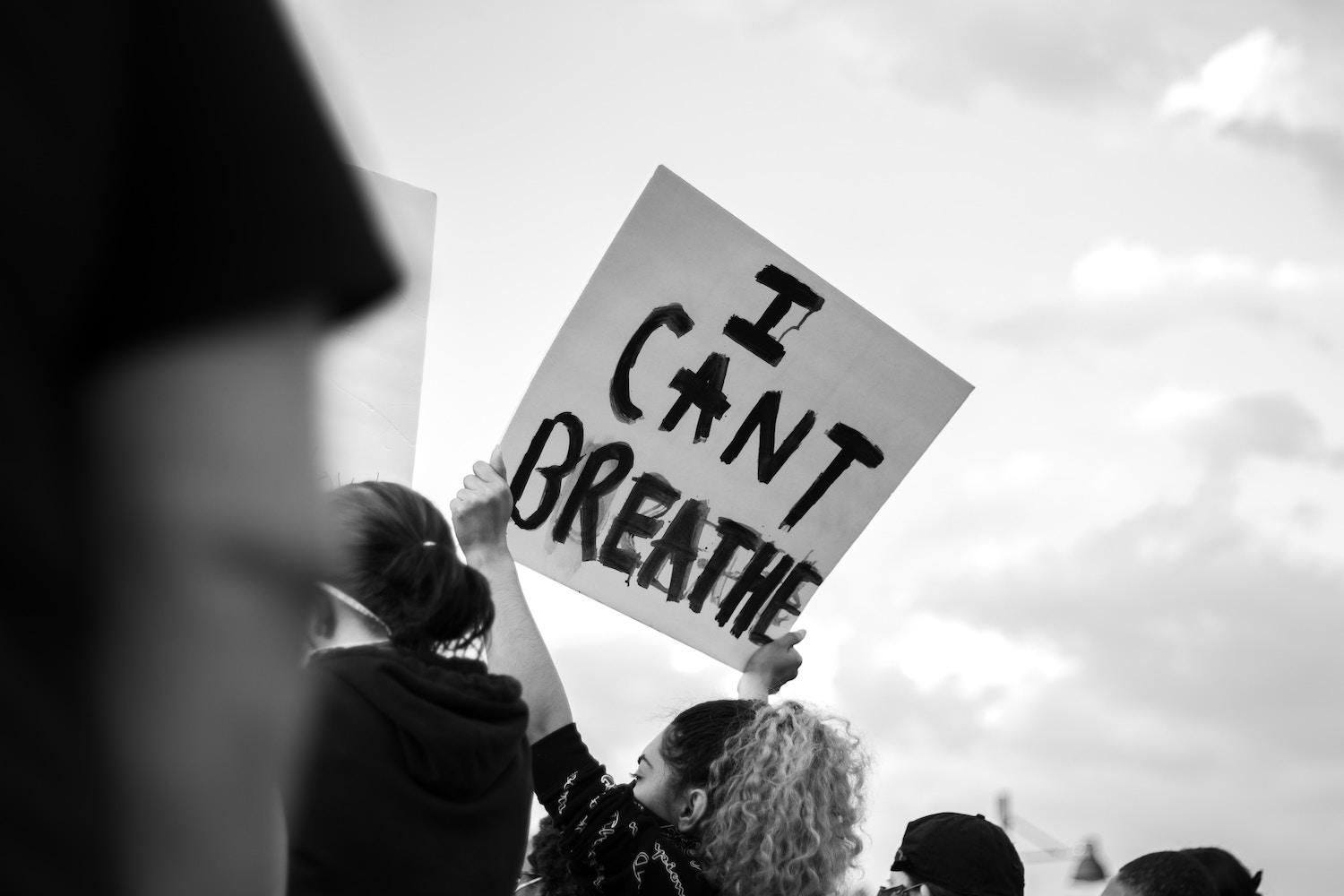 A protester holds a sign that reads "I can't breathe." 