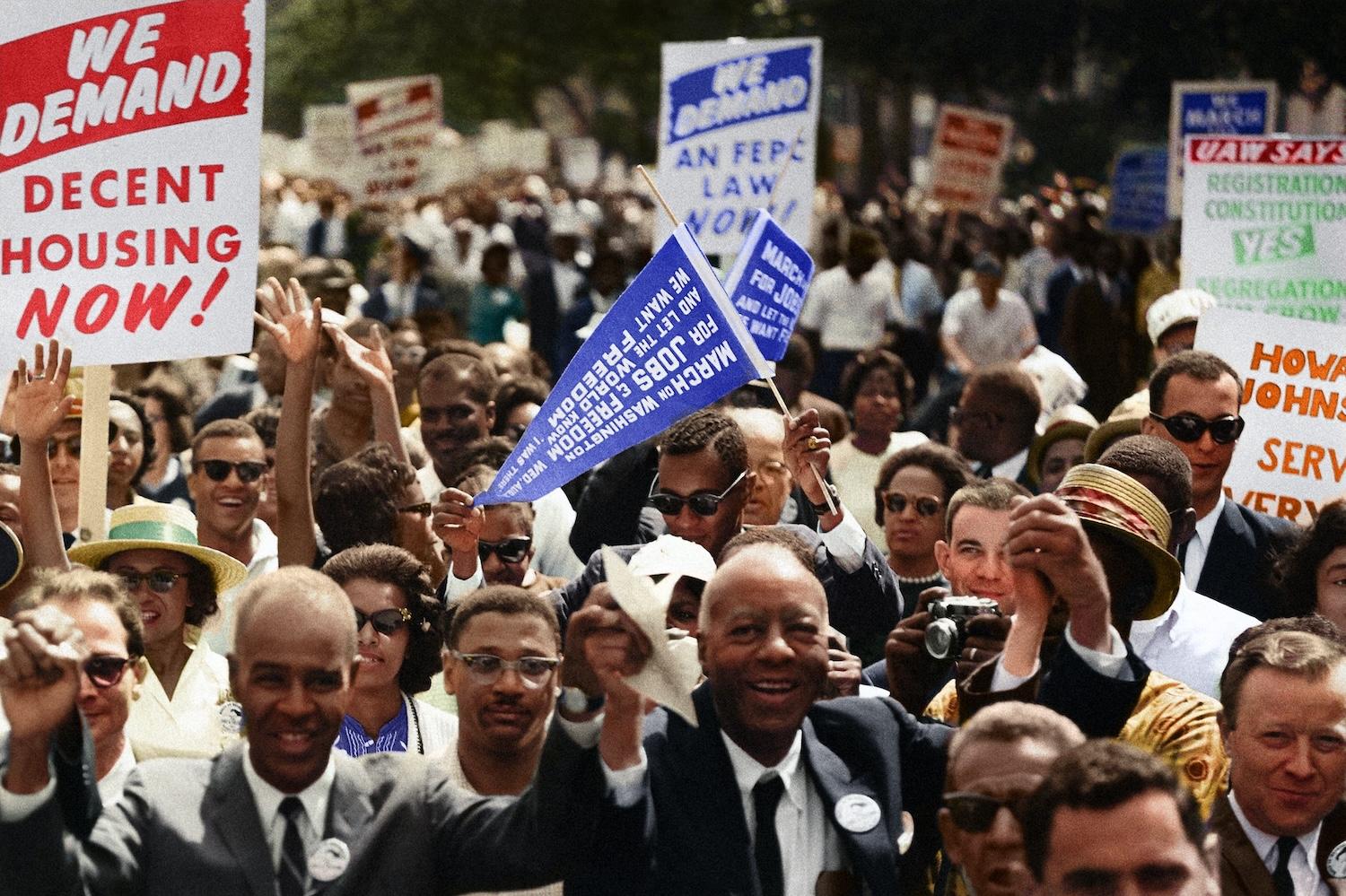 demonstrators attend the 1963 March on Washington - one sign reads 'we demand decent housing now' 