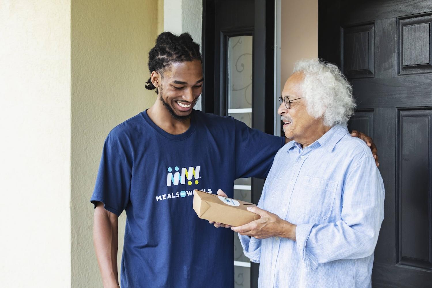 meals on wheels volunteer hands meal to a senior