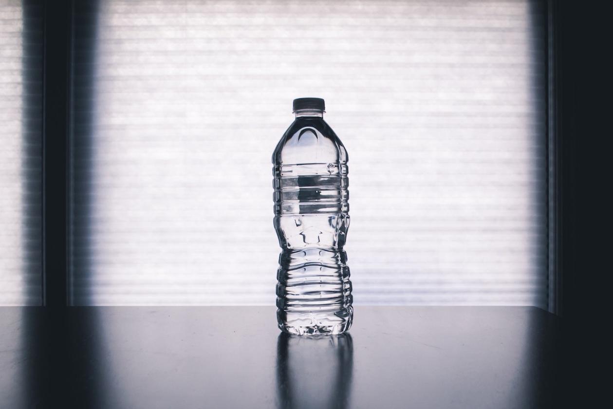 A full plastic water bottle on a table. 