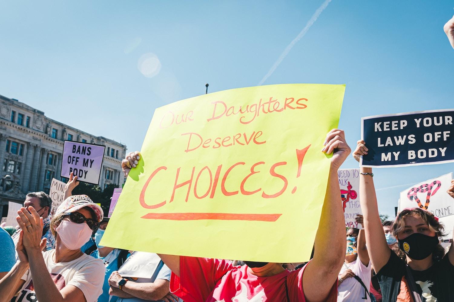 protesters hold signs at a rally for abortion rights 