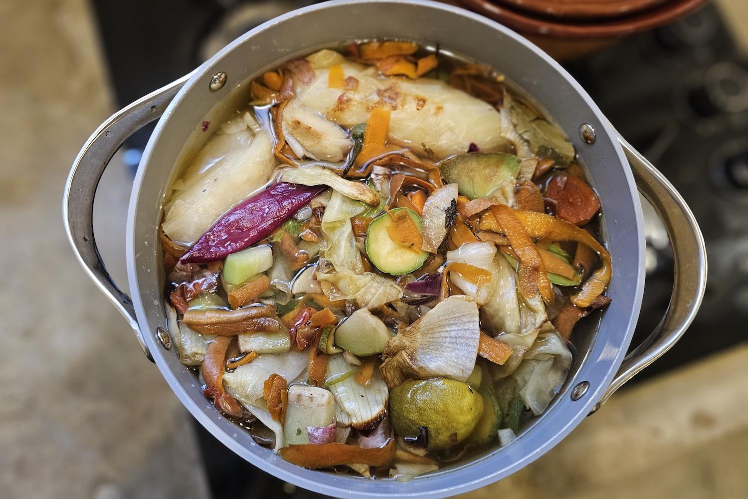 roasted vegetables in a pot with water - how to make vegetable broth from vegetable scraps