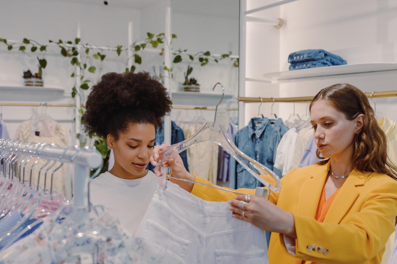 two women shopping for clothes in a retail store - how retail can combat greenwashing