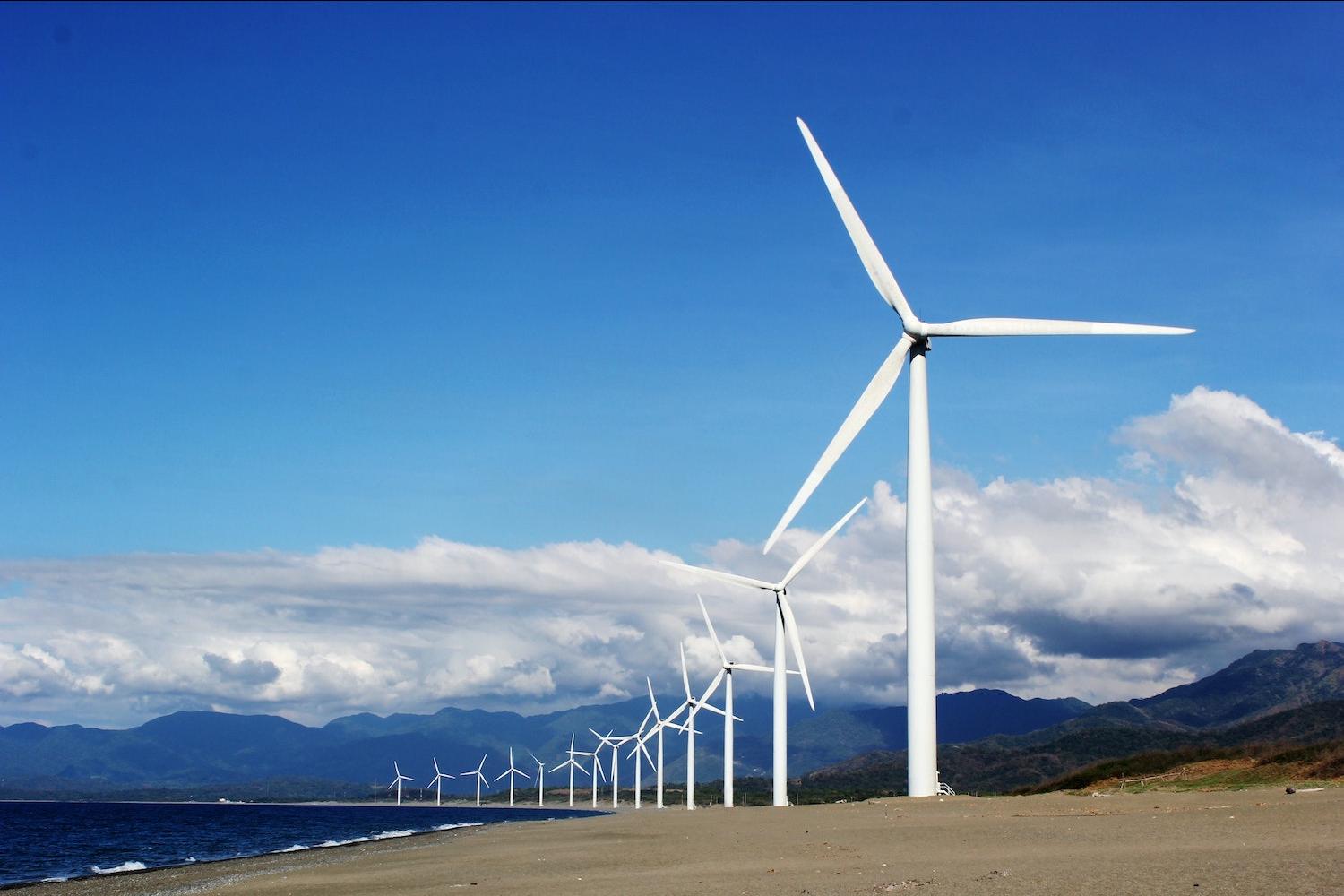 wind farm in the country against blue sky with clouds - renewable energy