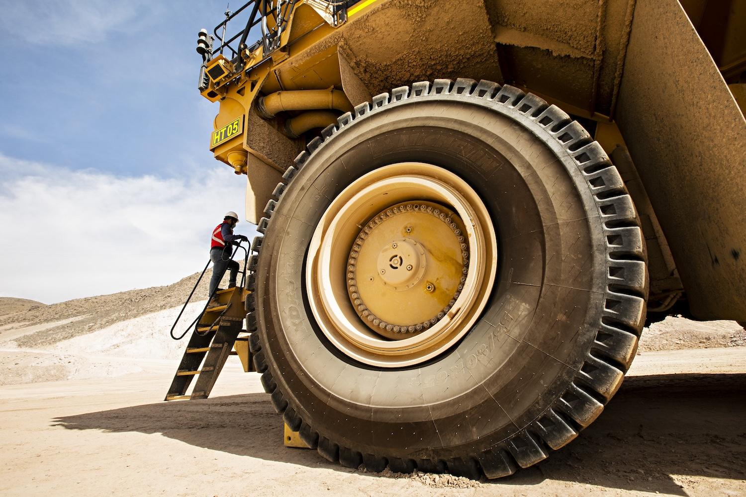 worker next to construction vehicle at a copper mine - human rights due diligence in the mining industry