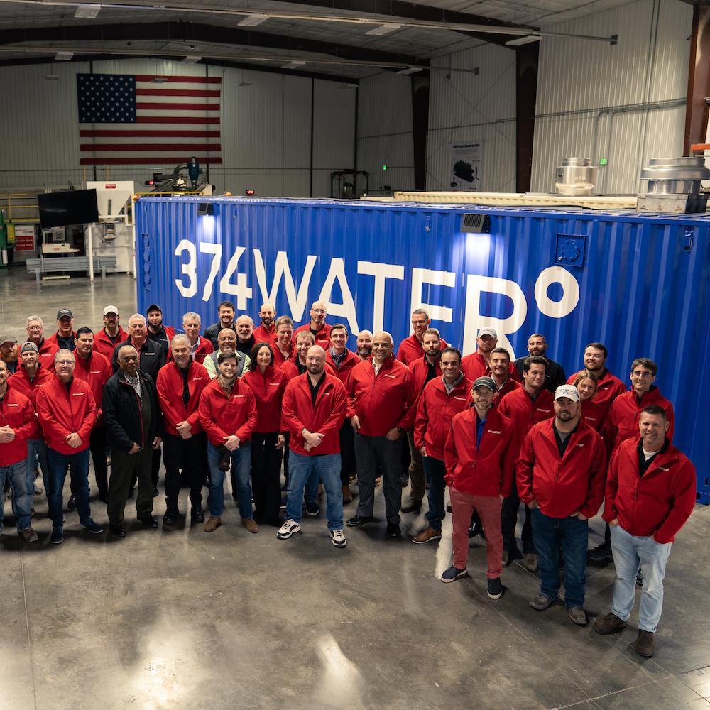 374water team in front of a reactor housed in a shipping container that can eliminate PFAS from wastewater