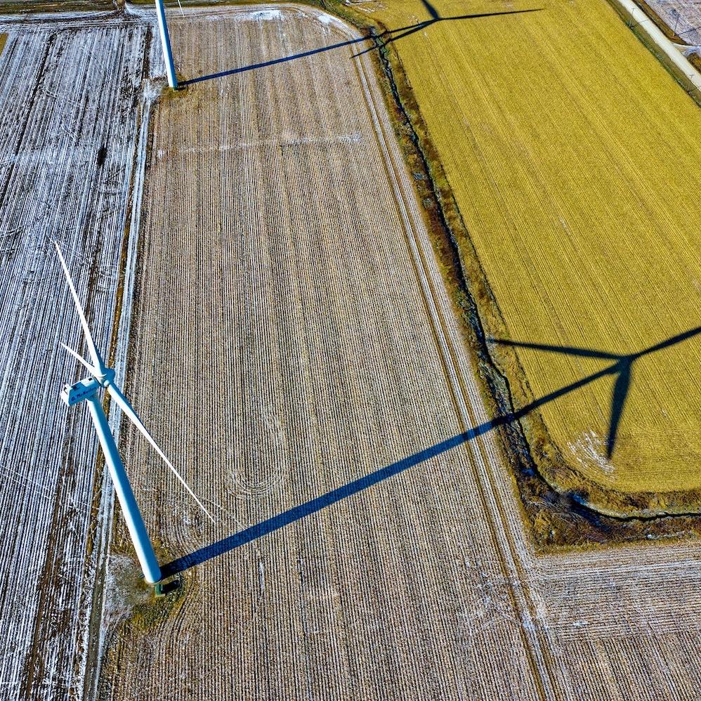 Aerial view of farms with wind turbines and a country road - engaging with suppliers on Scope 3