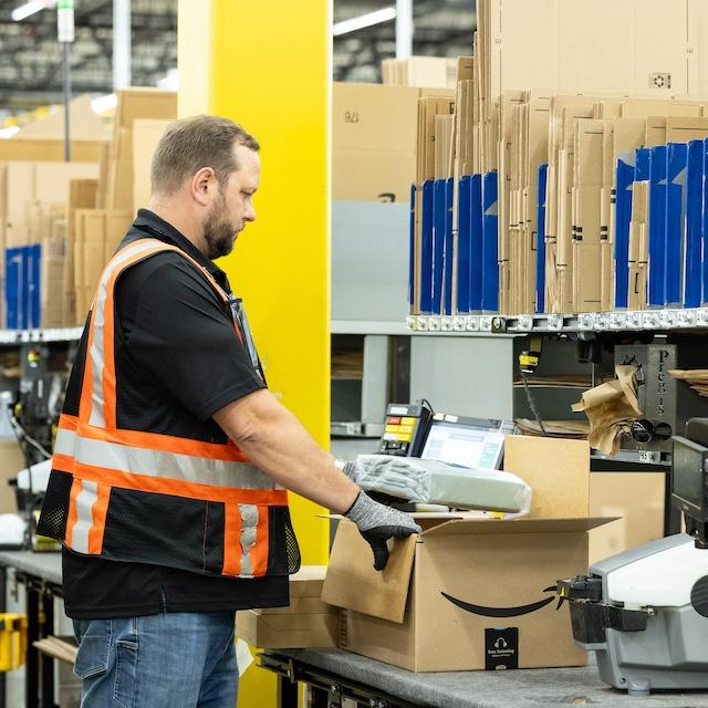 An Amazon employee packaging an order — artificial intelligence.