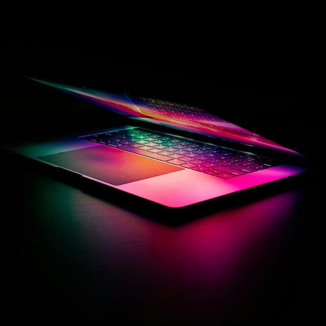 A laptop lit by multicolor light — artificial intelligence