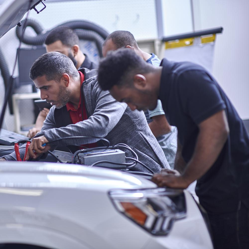 Students working on vehicles as a part of the Audi Education Partnership. 