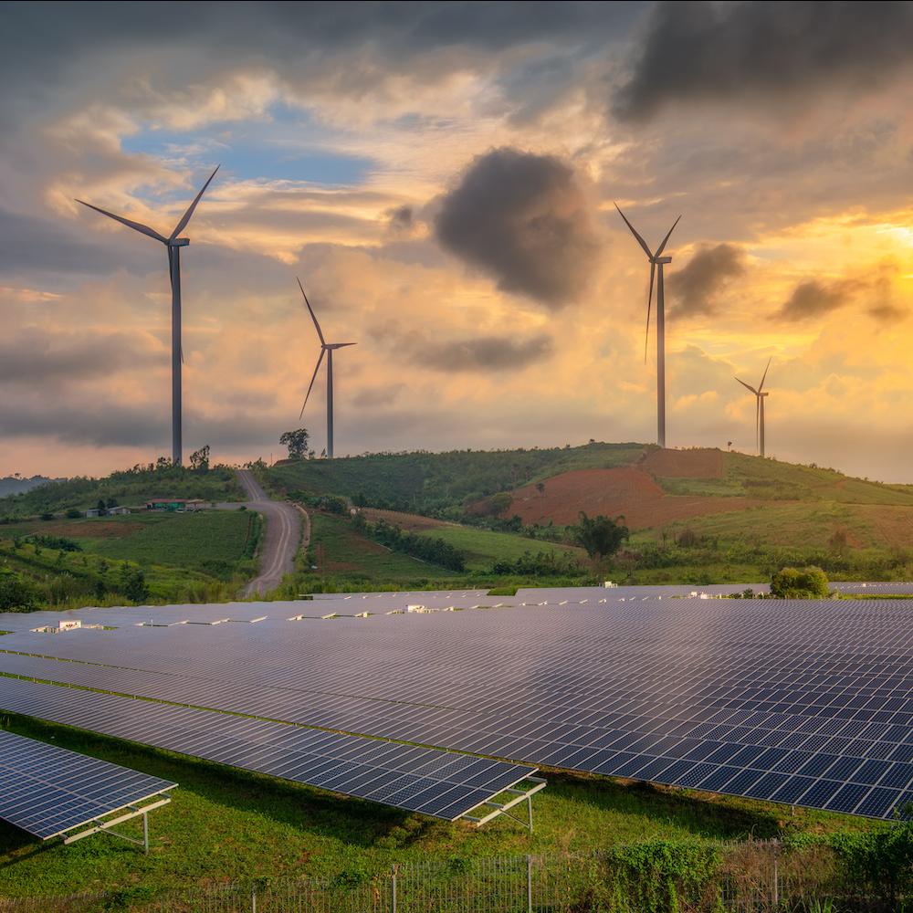 Clean Energy - Solar Panels and Wind Turbines in a field at sunset