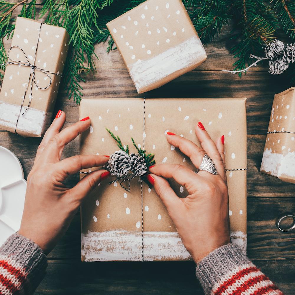 Hands Wrapping Holiday Gifts - Sustainable Holiday Gift Guide