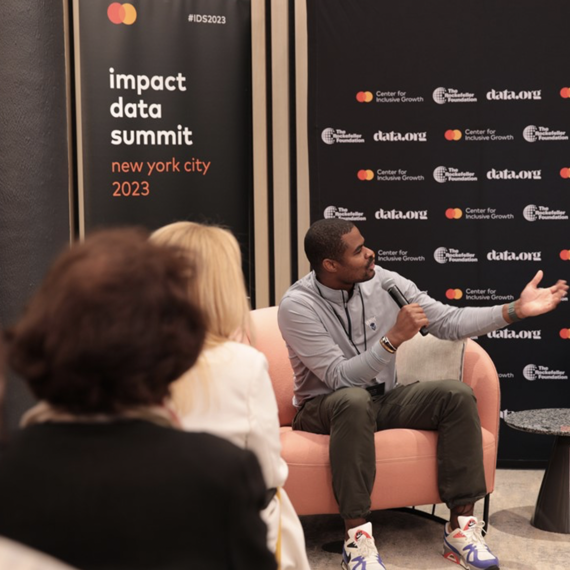 Mastercard Impact Data Summit - speaker talking on stage about AI for sustainability