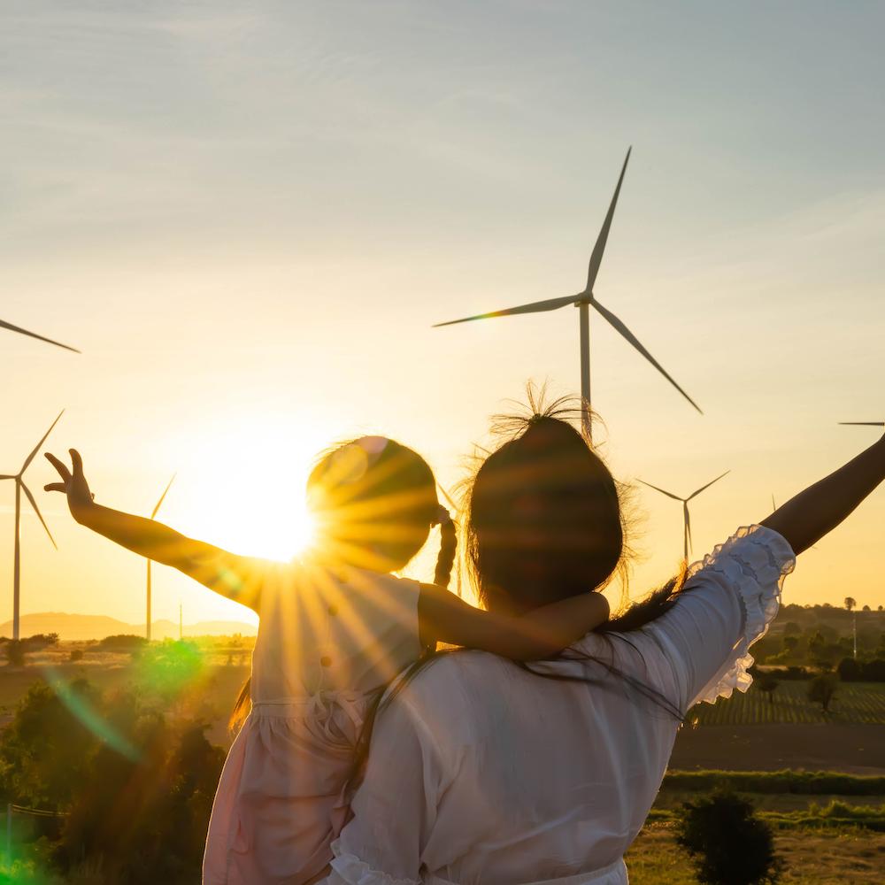 Mother and Daughter looking at wind farm - the journey to climate-positive