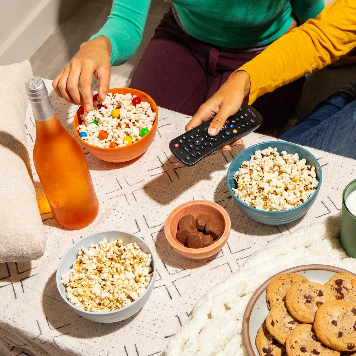 Two Friends Snacking and Watching Television