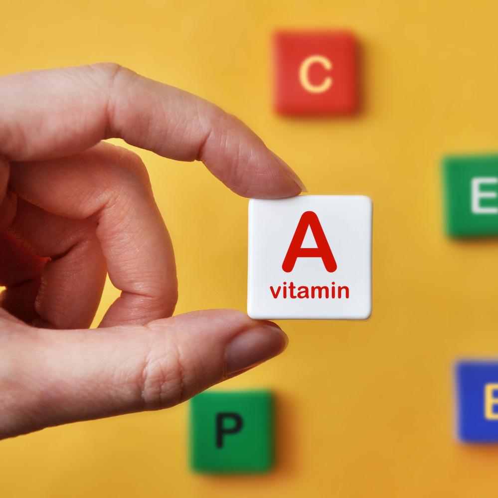 person holding letter tile that says vitamin A
