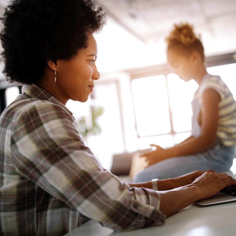 Woman working from Home with a Child - Tech Returnship offers options for women who leave the workforce to care for family