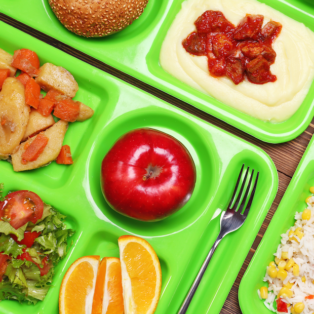 close-up of school lunch trays with food — school systems adopt reuse for serving trays and cutlery