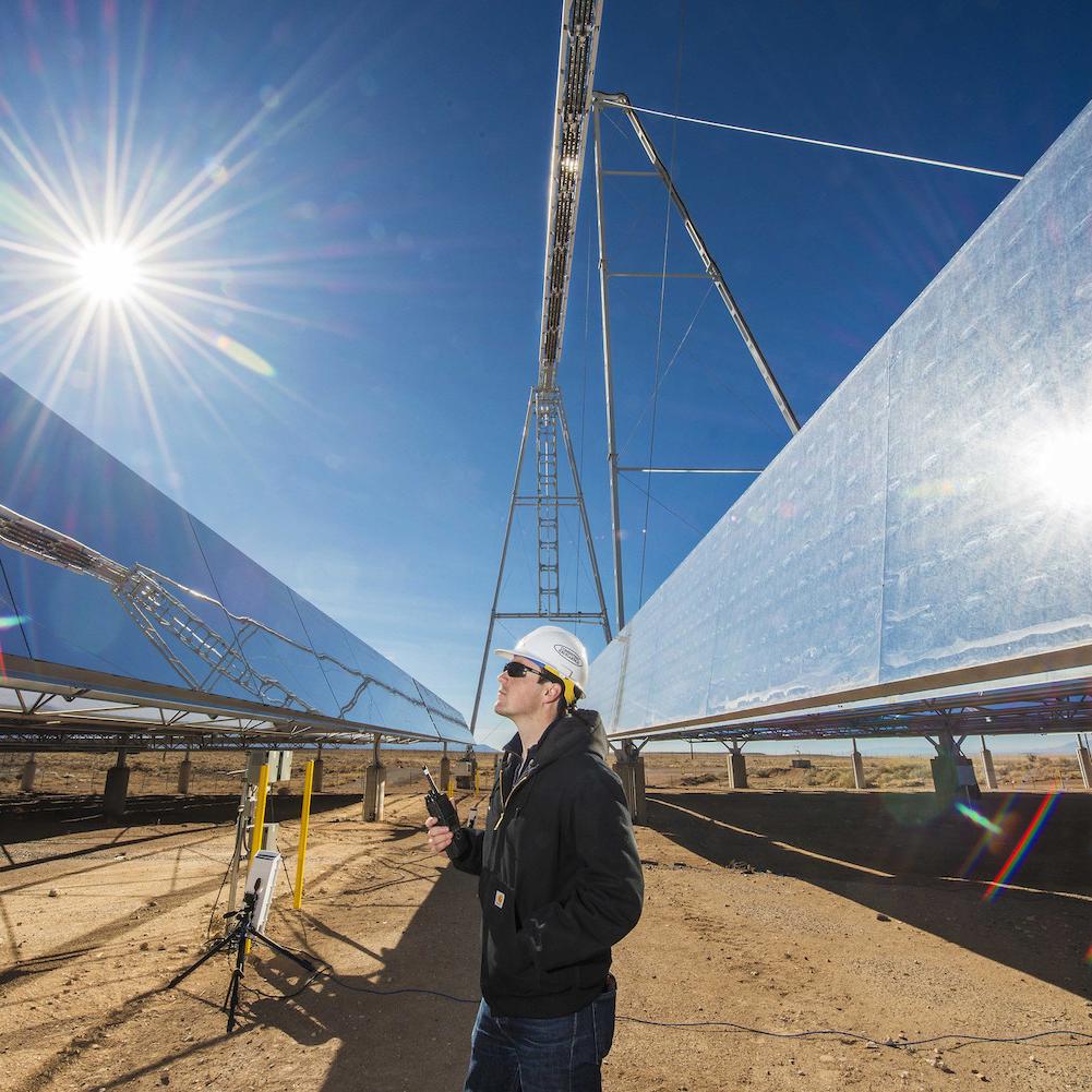 concentrating solar power - man stands at solar-thermal testing site in new mexico usa - clean power