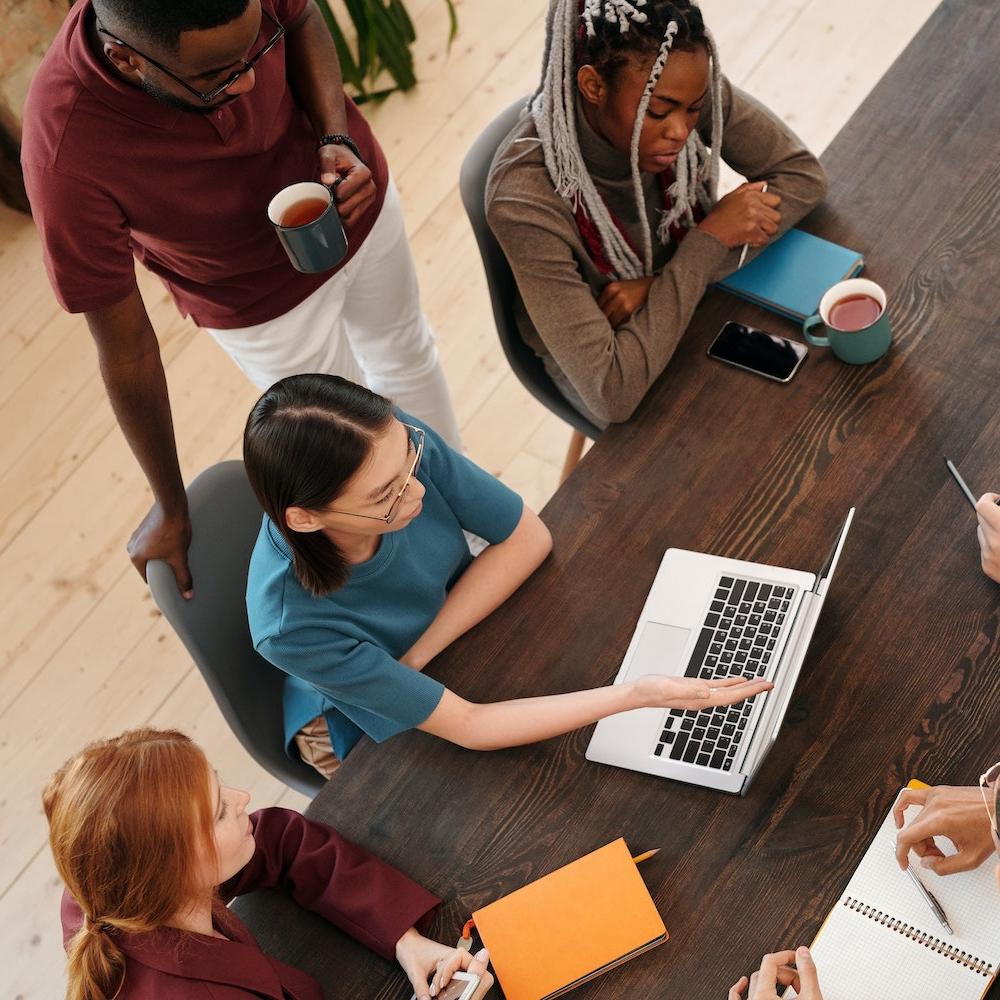 coworkers working at a shared desk - companies preparing for SEC climate disclosure rule