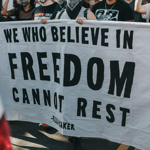 demonstrators carry a sign in support of racial equity and improving black communities at a demonstration after the death of george floyd