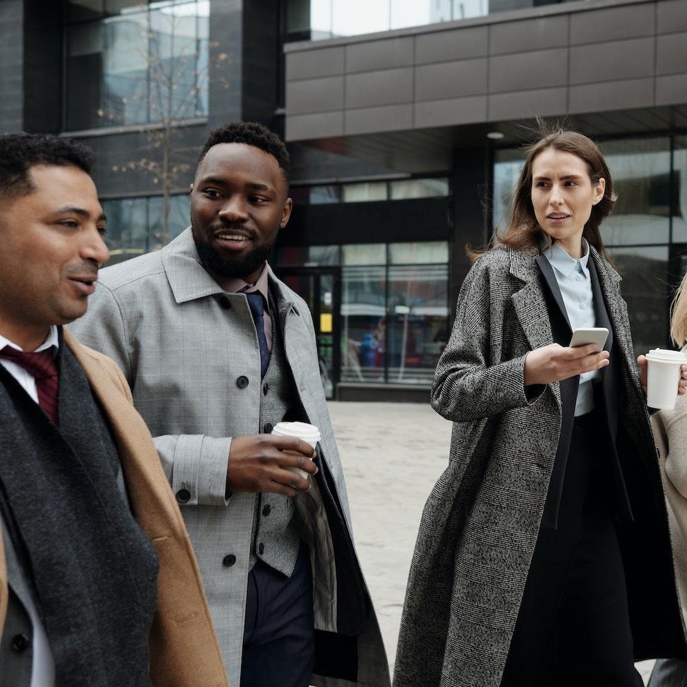 diverse coworkers professionals in business attire walking to work - corporate diversity disclosures are rising