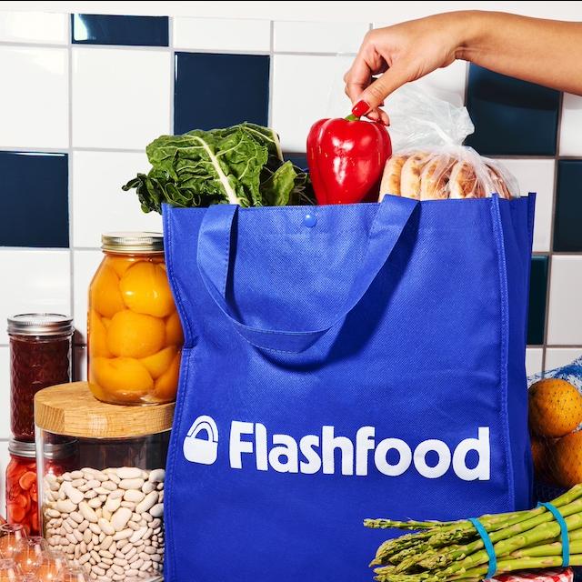 A person grabbing produce out of a bag from the food waste app Flashfood.