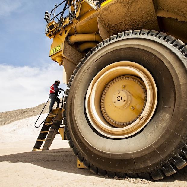 worker next to construction vehicle at a copper mine - human rights due diligence in the mining industry