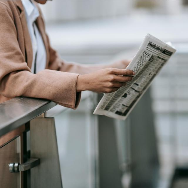 A person reading a newspaper. 