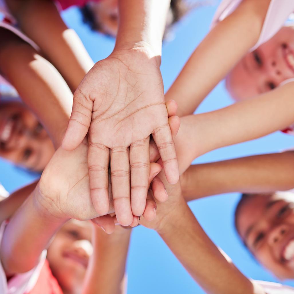 kids putting hands in center - youth sports