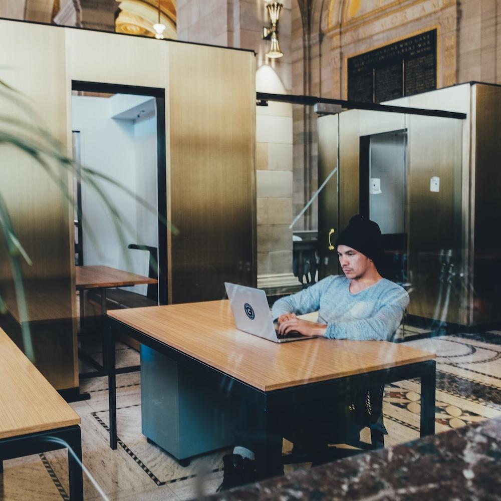 man working on laptop in shared office space - employee engagement