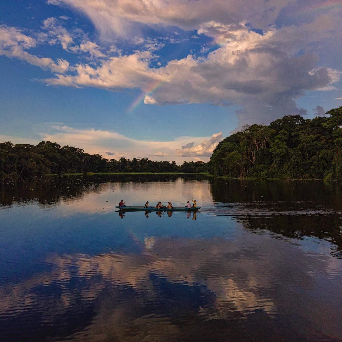 people on boat in amazon rainforest