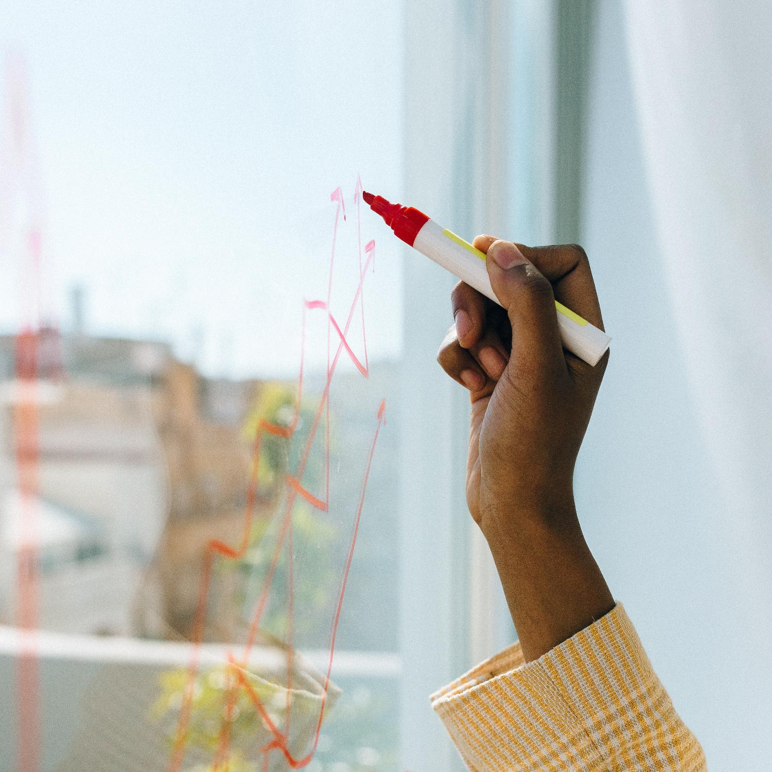 A photo of a hand drawing a diagram.