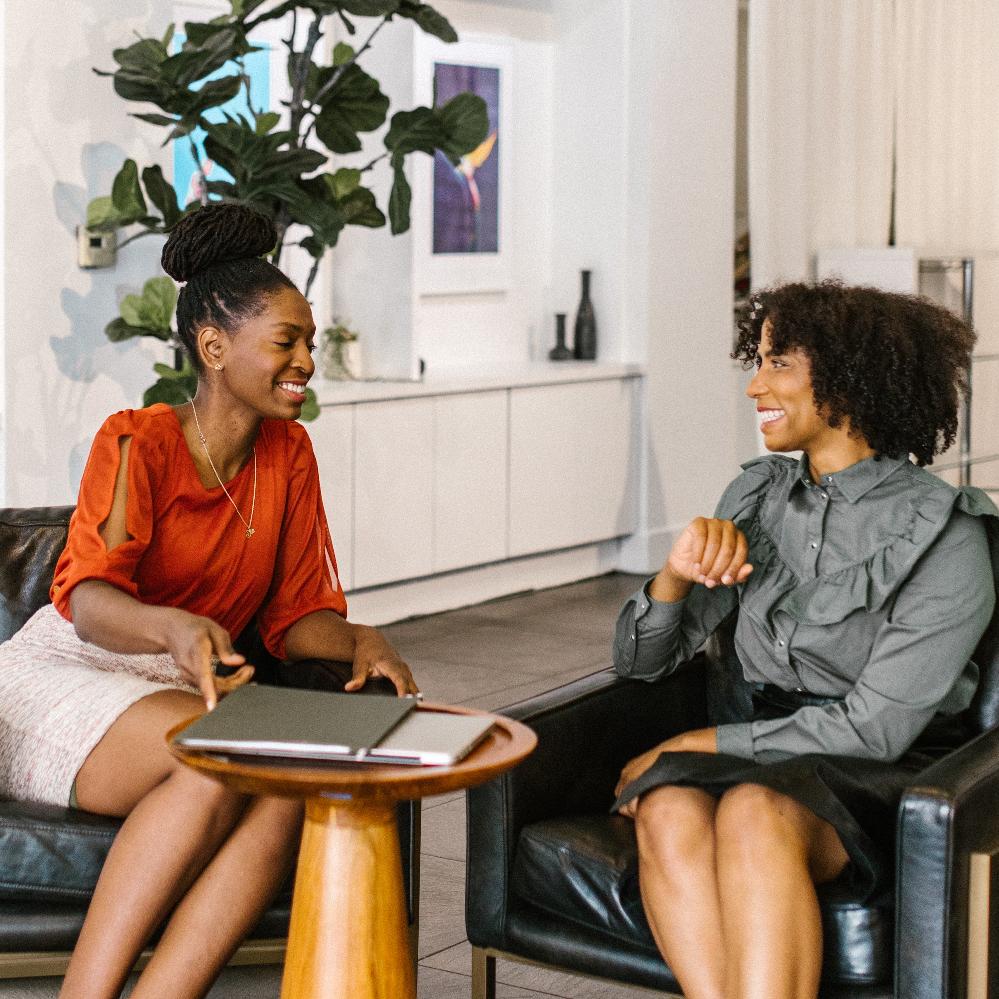 A photo of two women in an office having a discussion.