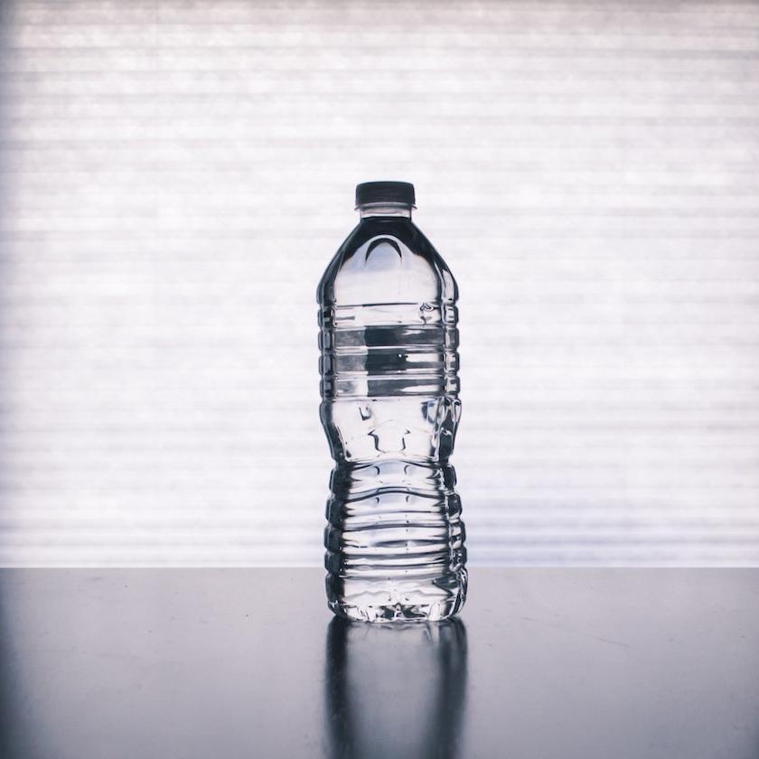 A full plastic water bottle on a table. 