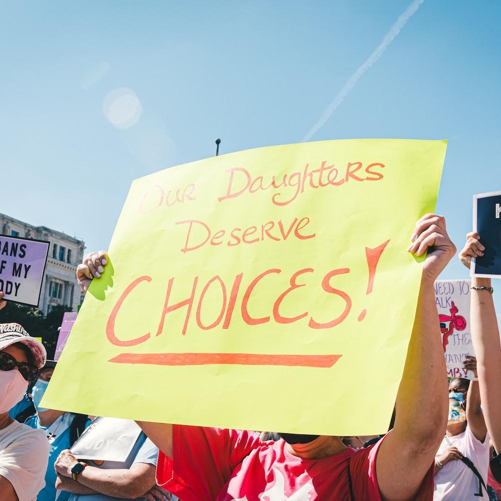 protesters hold signs at a rally for abortion rights