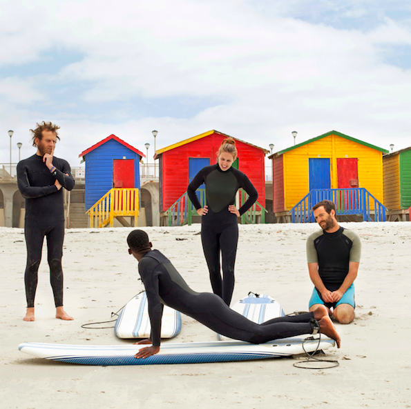 Travelers participate in a “Surf With Purpose” Social Impact Experience in Cape Town. Each lesson provides one month of surf therapy for a local child.