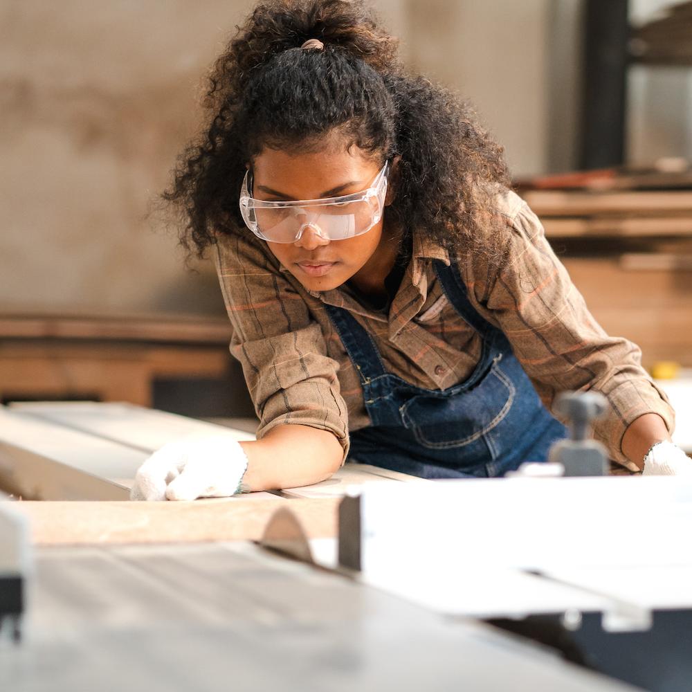 woman carpenter measuring wood - workforce training for skilled trades