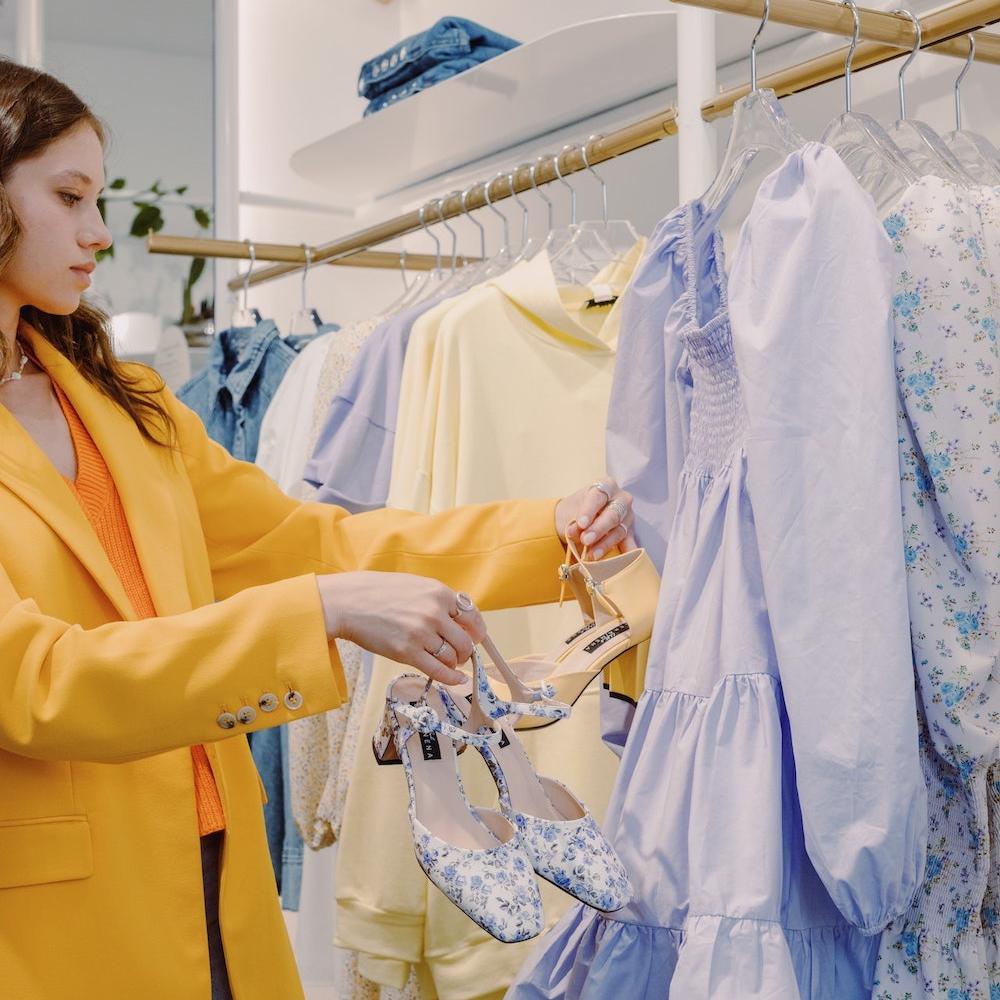woman shopping for clothing and shoes in a retail store - how retailers can combat greenwashing