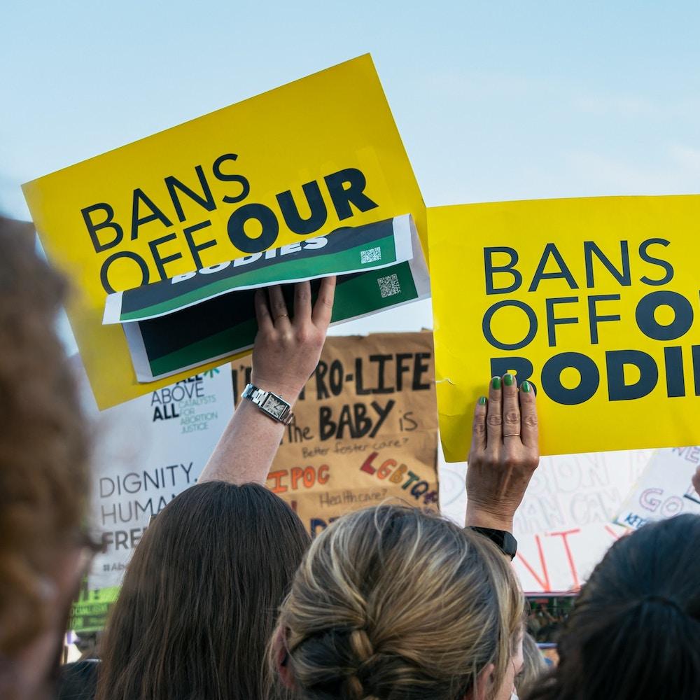 women hold signs in abortion rights protest - mifepristone ban roe v. wade overturned